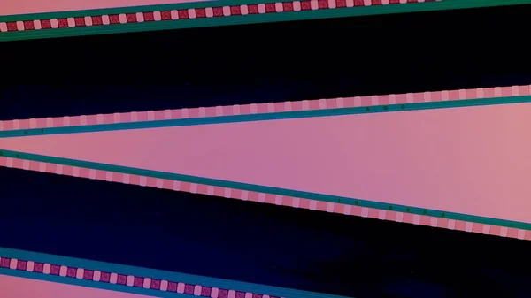 Dos Tiras Película Negra Sobre Fondo Rosa Cerca Marco Diapositiva — Foto de Stock
