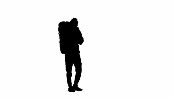 一个背着远足背包走路的男性游客的黑色轮廓 停下来挥挥手致意 一个男人在白色孤立的背景上徒步旅行 — 图库视频影像