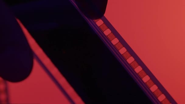 Silueta Película Rebobinado Oscuridad Sobre Fondo Rojo Cerca Película Retro — Vídeos de Stock