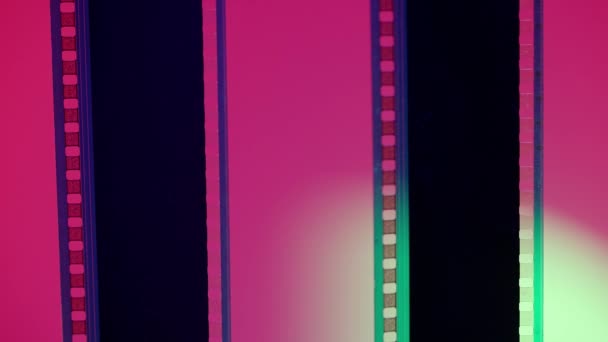 ピンクと白の勾配の背景に2つの垂直フィルムストリップを閉じます 35Mmフィルム スライド フレーム ロング レトロフィルムストリップフレーム コピースペース — ストック動画