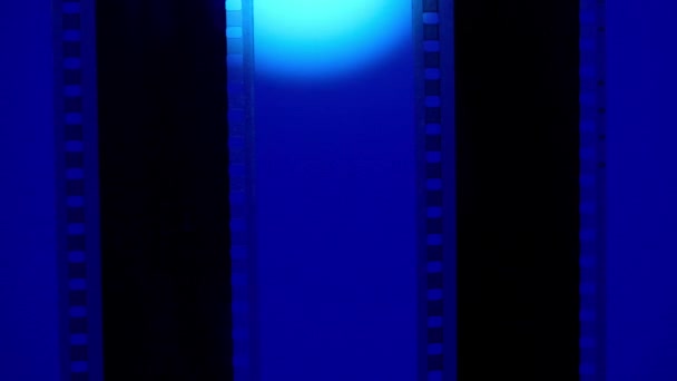Två Vertikala Filmremsor Blå Bakgrund Med Vitt Cirkulärt Ljus Närbild — Stockvideo