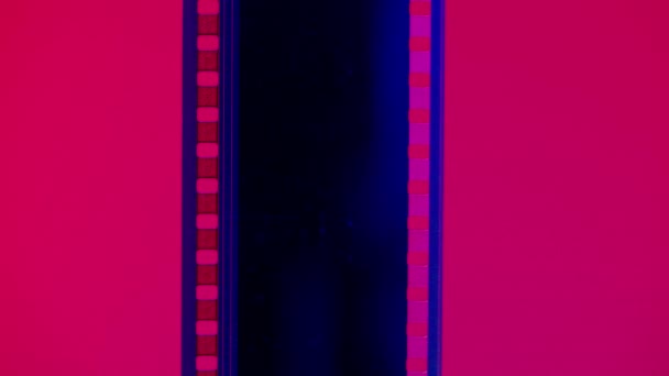 ピンクと緑の勾配の背景に垂直フィルムストリップ 閉じます 35Mmフィルム スライド フレーム ロング レトロフィルムストリップフレーム コピースペース — ストック動画