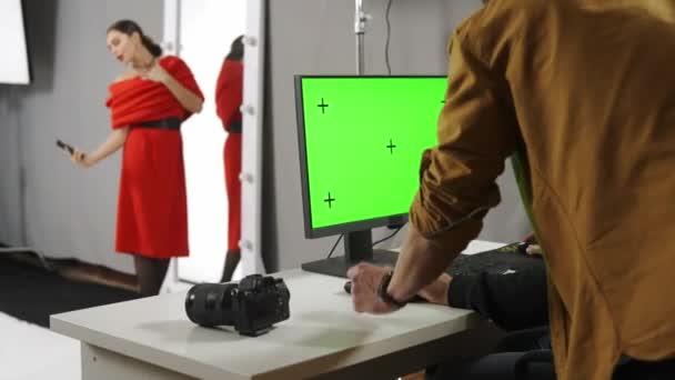 摄影和团队合作后台广告创意理念 工作室里的模特和制作团队 摄影师看着彩色键绿色屏幕计算机 模型拍摄自拍照 — 图库视频影像