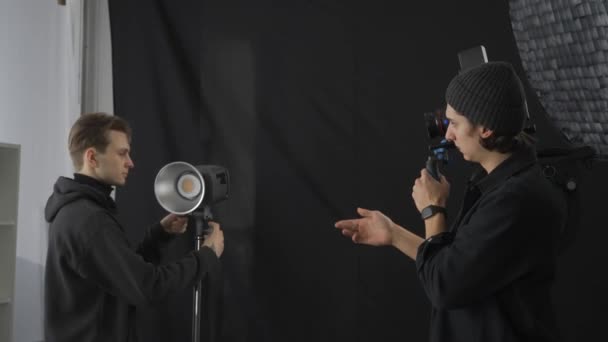 Muž Kameraman Diskutuje Procesu Střelby Mužským Osvětlovačem Samec Osvětlovacího Technika — Stock video