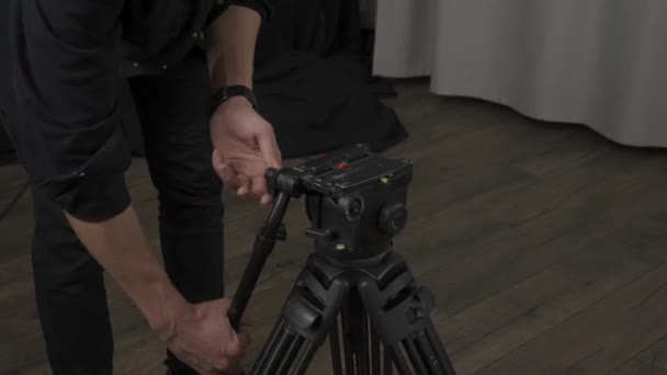 Ένας Κάμεραμαν Ανοίγει Και Θέτει Ένα Τρίποδο Για Μια Επαγγελματική — Αρχείο Βίντεο