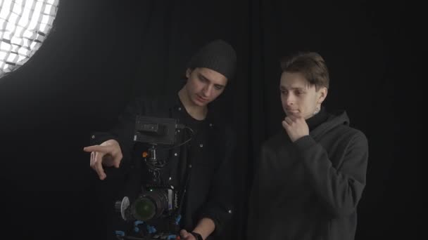 Αρσενικό Videographer Και Βοηθός Στέκεται Κοντά Μια Επαγγελματική Κάμερα Και — Αρχείο Βίντεο