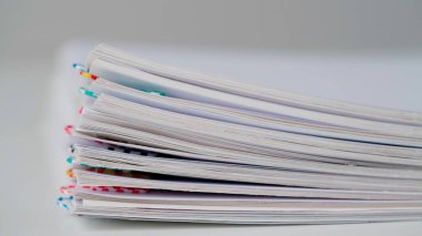 İş yeri evrakları, rutin yaratıcı reklam konsepti. Kağıt kağıtların beyaz arkaplanda zaman aşımı. İşletme kağıdı dosyalarının masadaki klipsli hareketini durdur, çok yakın plan.