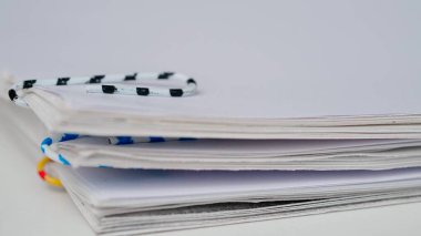 İş yeri evrakları, rutin yaratıcı reklam konsepti. Kağıt kağıtların beyaz arkaplanda zaman aşımı. Renkli klipli dokümanlar ile iş kağıt dosyalarının çekim durdurma hareketini kapat.