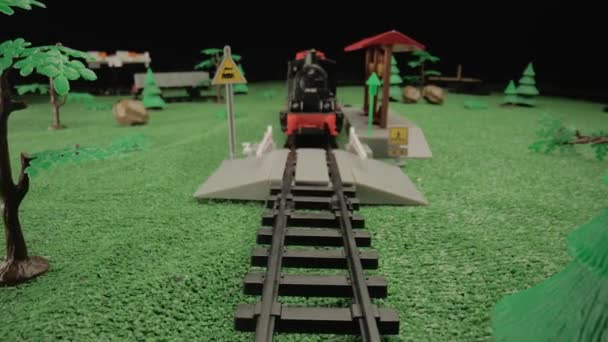 一辆儿童用塑料蒸汽机车的模型站在绿树成荫的平台上 适合用于儿童节目或玩具广告的氛围 — 图库视频影像