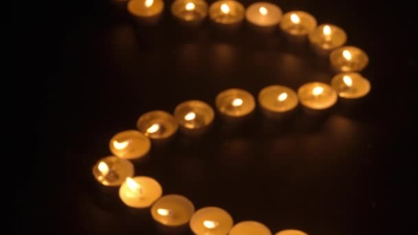 一排在黑色背景上燃着的蜡烛 从火焰中发出的柔和温暖的光营造出一种舒适的和平气氛 教堂或庙宇 宗教和法令中的纪念日概念 — 图库视频影像