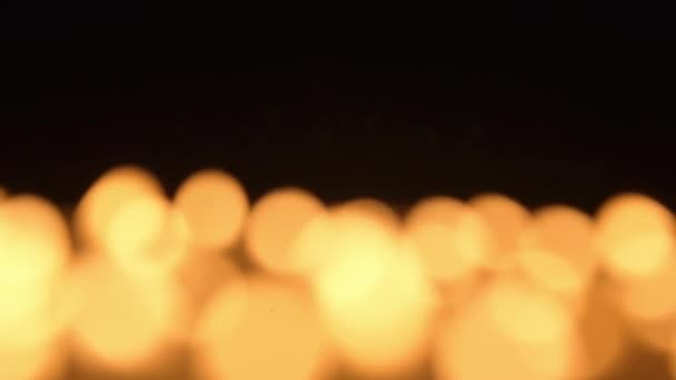燃烧着的蜡烛分散了焦距 在黑色背景上燃烧着的蜡烛火焰会使模糊 并产生防爆效果 悼念日 广告和设计项目的背景 — 图库视频影像