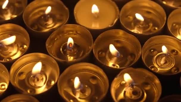 许多人在用融化的蜡燃着蜡烛 从火中发出的柔和温暖的光 营造出一种祥和祥和的气氛 教堂或庙宇 宗教和法令中的纪念日概念 — 图库视频影像