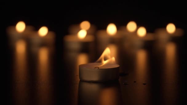 点着蜡烛蜡烛在黑色的背景下燃烧 风一吹 火焰就会移动 纪念日的概念 广告和设计项目的背景 — 图库视频影像