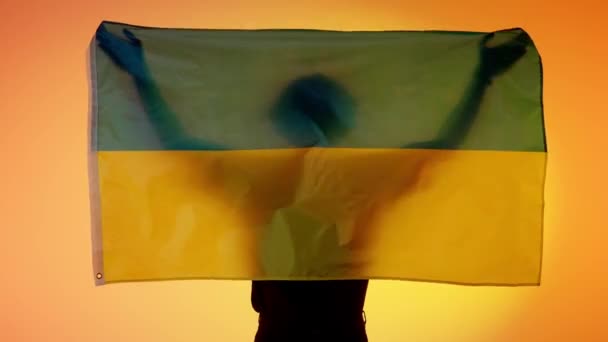 国旗爱国广告的概念 在黄色背景下高举大旗的人物形象 手握乌克兰国旗的人的轮廓 — 图库视频影像