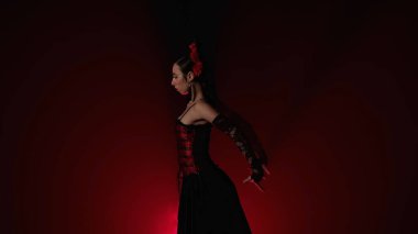 Modern koreografi bir dans. Kırmızı ışık ve dumanla siyah arka planda dans eden kadın. Kırmızı ve siyah elbiseli İspanyol dansçı flamenko koreografisinin unsurlarını gösteriyor.