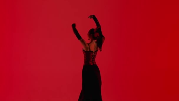 现代编舞是一种舞蹈 在红色背景下跳舞的女舞蹈演员 身着佛朗明哥风格服装的女性在演播室里用她的手和身体表演优雅的西班牙舞步 — 图库视频影像