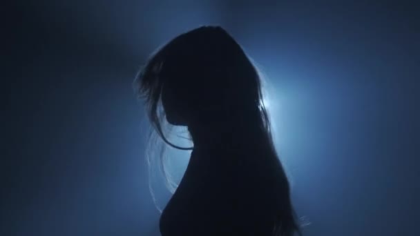 照明コンセプトのシルエット スタジオの黒い背景の明るいライトに対する女性モデル 女性プロフィール 暗闇の光線に囲まれたシルエットダンス — ストック動画