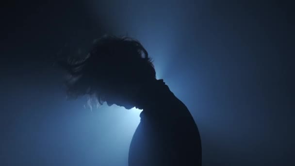 照明コンセプトのシルエット スタジオの黒い背景に明るいストロボライトに対する男性モデル 暗闇に光の光に囲まれたマンクラバーシルエットダンス — ストック動画