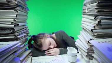 Sıkı çalışma konsepti. Yorgun, genç bir iş kadını ofis çalışanı gece geç saatlere kadar evrak işleriyle meşgul. Masada kağıt üzerinde uyuyan bir kadın. Yeşil Ekran.