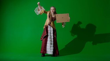 Tarihsel kişi modern yaşam tarzı reklamı. Krom anahtar yeşil ekran arka planda antik kıyafetli bir kadın. Rönesans elbisesi giymiş kadın elinde karton levha ve protesto sloganı taşıyor..