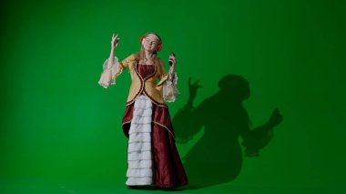 Tarihsel kişi modern yaşam tarzı reklamı. Krom anahtar yeşil ekranda antik kıyafetli bir kadın. Rönesans tarzı giyinen, kulaklıklı bir kadın akıllı telefondan müzik dinliyor ve dans ediyor..