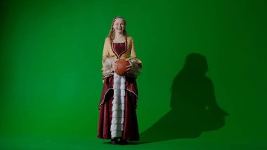 Tarihsel kişi modern yaşam tarzı reklamı. Krom anahtar yeşil ekran arka planında eski giysili bir kadın. Rönesans tarzı elbise giymiş bir kadın basketbol topu tutuyor..