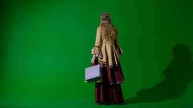 Tarihsel kişi modern yaşam tarzı reklamı. Krom anahtar yeşil ekran arka planında eski giysili bir kadın. Rönesans tarzı elbisesi ve bir sürü hediye çantası olan bir kadın..