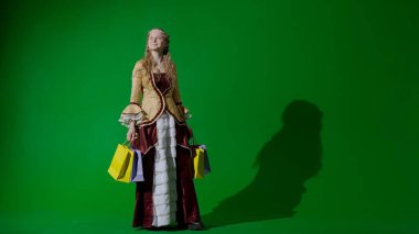 Tarihsel kişi modern yaşam tarzı reklamı. Krom anahtar yeşil ekran arka planında eski giysili bir kadın. Rönesans tarzı elbisesi ve bir sürü hediye çantası olan bir kadın..
