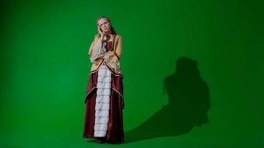 Tarihsel kişi modern yaşam tarzı reklamı. Krom anahtar yeşil ekran arka planında eski giysili bir kadın. Rönesans tarzı elbiseli bir kadın kameraya bakıyor, üzgün bir yüz..