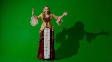 Tarihsel kişi modern yaşam tarzı reklamı. Krom anahtar yeşil ekran arka planında eski giysili bir kadın. Rönesans tarzı elbiseli bir kadın kameraya kızgın sinirli bağırarak bakıyor..