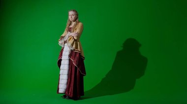 Tarihsel kişi modern yaşam tarzı reklamı. Krom anahtar yeşil ekran arka planında eski giysili bir kadın. Rönesans tarzı elbiseli bir kadın kameraya bakıyor, ağlıyor..