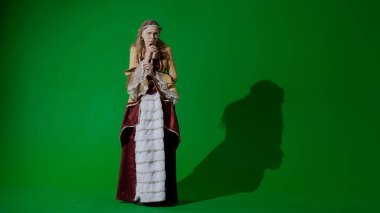 Tarihsel kişi modern yaşam tarzı reklamı. Krom anahtar yeşil ekran arka planda antik kıyafetli bir kadın. Rönesans tarzı elbiseli bir kadın kameraya bakıyor, korkmuş bir surat..