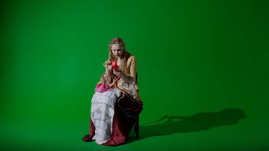 Tarihsel kişi modern yaşam tarzı reklamı. Krom anahtar yeşil ekran arka planında eski giysili bir kadın. Rönesans tarzı elbiseli bir kadın eski moda bir telefonla arıyor ve konuşuyor..