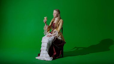 Tarihsel kişi modern yaşam tarzı reklamı. Krom anahtar yeşil ekran arka planında eski giysili bir kadın. Rönesans tarzı elbiseli bir kadın oturmuş kağıt bardaktan kahve içiyor..