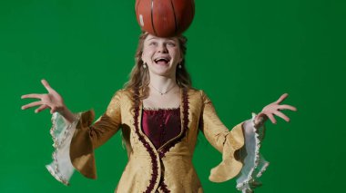 Tarihsel kişi modern yaşam tarzı reklamı. Krom anahtar yeşil ekran arka planında eski giysili bir kadın. Rönesans tarzı elbiseli kadın basketbol topu atıyor..