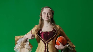 Tarihsel kişi modern yaşam tarzı reklamı. Krom anahtar yeşil ekranda eski bir kıyafet giymiş kadın. Rönesans tarzı elbise giymiş bir kadın elinde Amerikan futbolu topu gülümsemesi tutuyor..