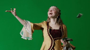 Tarihsel kişi modern yaşam tarzı reklamı. Krom anahtar yeşil ekran arka planında eski giysili bir kadın. Rönesans tarzı elbiseli bir kadın havaya para fırlatıyor..