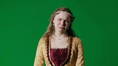 Tarihsel kişi modern yaşam tarzı reklamı. Krom anahtar yeşil ekran arka planında eski giysili bir kadın. Rönesans tarzı elbiseli bir kadın kameraya bakıyor, üzgün bir yüz..