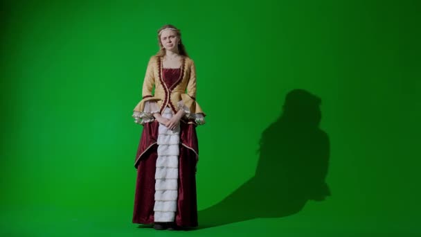 歴史的人物現代ライフスタイル広告 クロマキーの緑色の背景に古代の服を着た女性 カメラを見てポーズするルネッサンススタイルのドレスの女性 悲しい顔 — ストック動画