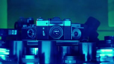 Neon mavi ışıkta mercek koleksiyonu olan bir Retro kamera. Eski tasarım, eski lensler. Fotoğrafçılar için antikalar. Eski teknoloji, hobiler, yaratıcılık. Fotoğraf sanatı. Kapat.