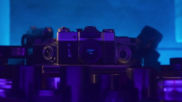 带有一系列霓虹灯蓝光镜头的复古相机 老式设计 老式镜片 摄影师的古董 老技术 创造力 摄影艺术 靠近点 — 图库视频影像