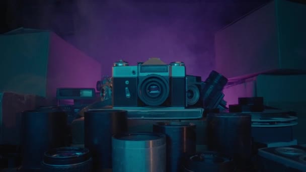 古董相机和镜头的古董收藏 让自己沉浸在一个神秘和神奇的氛围中 在这个视频中 老式相机和镜头被霓虹灯和烟雾包裹着 — 图库视频影像