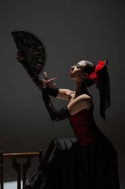 Modern koreografi bir dans. Sahne ışıkları altında siyah arka planda dans eden bir kadın. Kırmızı-siyah elbiseli İspanyol dansçı tutkulu flamenko dansçıları..