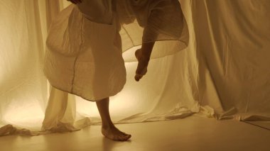 Siluet çağdaş deneysel koreografi konsepti. Stüdyoda kadın dansçı sahne alıyor. Genç kız sıcak arka ışığa karşı dans ediyor..