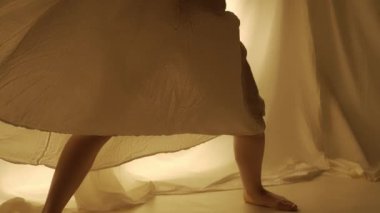 Siluet çağdaş deneysel koreografi konsepti. Stüdyoda kadın dansçı sahne alıyor. Genç kız sıcak arka ışığa karşı dans ediyor..