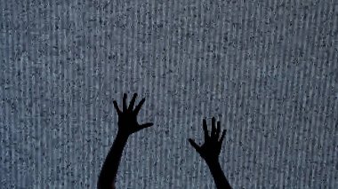 Cadılar Bayramı korku filmi yaratıcı konsepti. Siluet dijital televizyon ekranına karşı. Gerilim sahnesi kadın silueti elleri büyük dijital ekranda gürültüyle emekliyor..