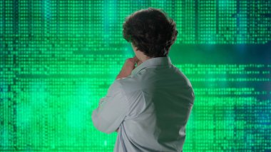 Geleceğin üniversitesi ve yapay zeka konsepti. Büyük dijital ekrana karşı bilişim uzmanı. Arka plan genç mühendis bilim adamı dijital kod yazılım verileri ile ekranın önünde.