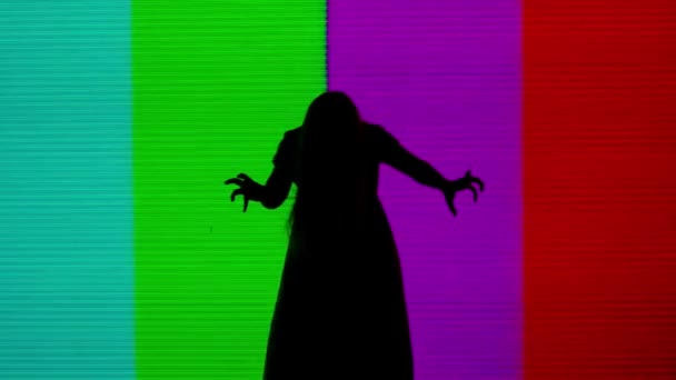 ハロウィンホラー映画クリエイティブコンセプト デジタルテレビ画面に対するシルエット スリラーのシーン 信号なしで大きなデジタル スクリーンの前にゾンビのようにポーズするドレスの不気味な女性 — ストック動画