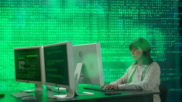 Geleceğin üniversitesi ve yapay zeka konsepti. Büyük dijital ekrana karşı bilişim uzmanı. Afrikalı Amerikalı kadın programcı ekrandaki dijital kod veri sürecinin önünde bilgisayar üzerinde çalışıyor.