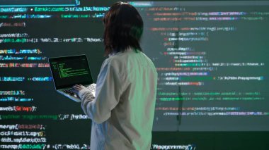 Geleceğin üniversitesi ve yapay zeka konsepti. Büyük dijital ekrana karşı bilişim uzmanı. Afrika kökenli Amerikalı mühendis kadın bilgisayar mühendisi ekranın önünde dijital kodla yazı yazıyor.